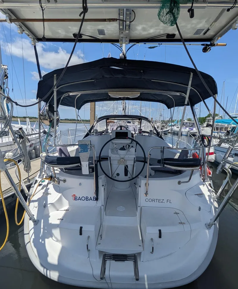 Slide: The Image of 2001 Hunter 380 sailboat docked in Cortez, FL, featuring a spacious cockpit and steering wheel. - 9