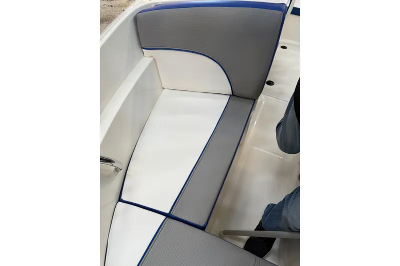 Slide: The Image of 2012 Sea Ray 190 Sport boat interior seating with gray and white upholstery. - 10