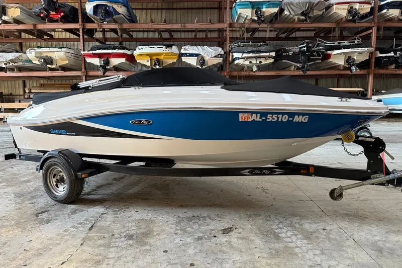 Slide: The Image of 2012 Sea Ray 190 Sport boat in storage, blue and white design, on a trailer. - 3