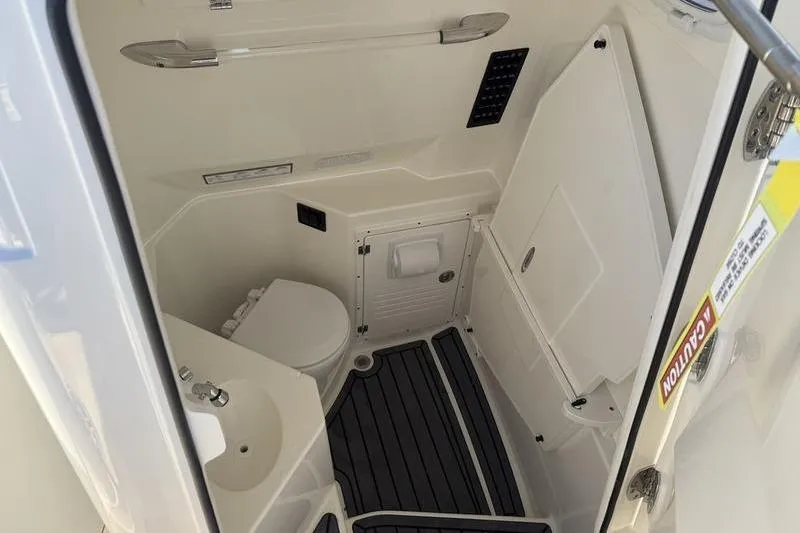 Slide: The Image of 2026 Cobia 265 Open Center Console boat interior with compact bathroom amenities. - 10