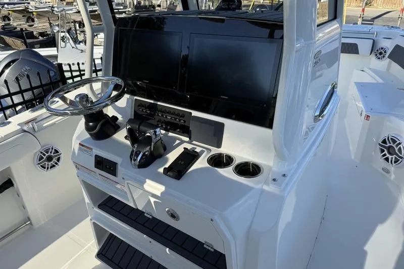 Slide: The Image of 2026 Cobia 265 Open Center Console boat dashboard with steering wheel and controls. - 11