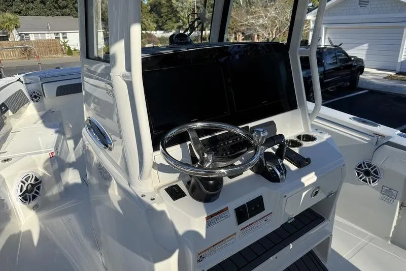 Slide: The Image of 2026 Cobia 265 Open Center Console boat interior with steering wheel and control panel. - 12