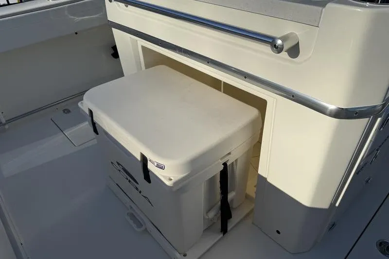Slide: The Image of 2026 Cobia 265 Open Center Console boat with storage compartment and cooler. - 17
