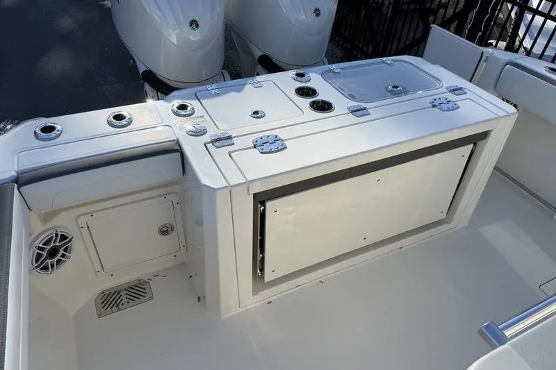 Slide: The Image of 2026 Cobia 265 Open Center Console boat interior with storage and fishing rod holders. - 18