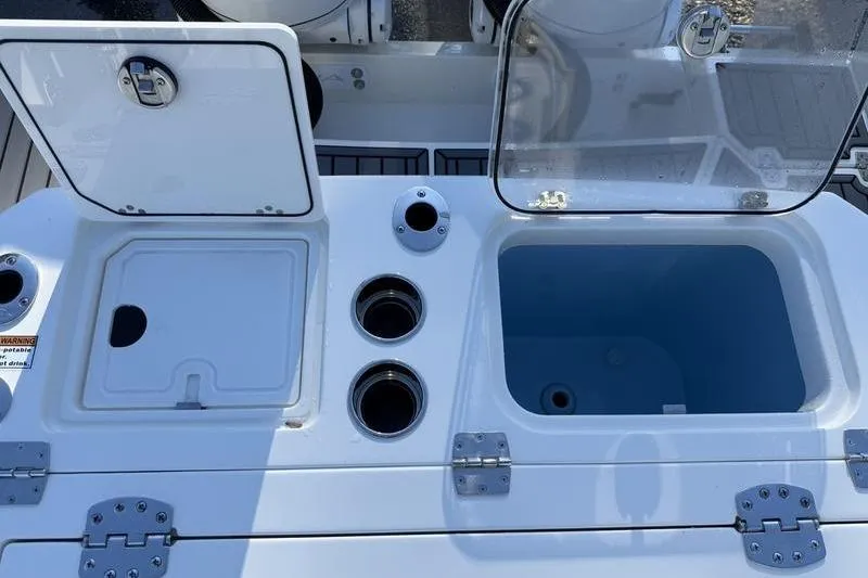 Slide: The Image of 2026 Cobia 265 Open Center Console boat with open storage compartments and cup holders. - 23