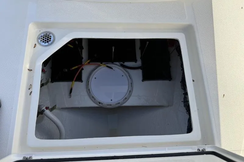 Slide: The Image of 2026 Cobia 265 Open Center Console storage compartment with wiring and drainage system. - 26