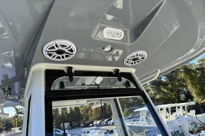Slide: The Image of 2026 Cobia 265 Open Center Console boat with speakers and lighting on the overhead console. - 29