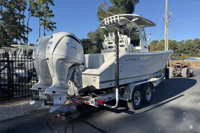 Slide: The Image of 2026 Cobia 265 Open Center Console boat on trailer with dual Yamaha engines. - 3