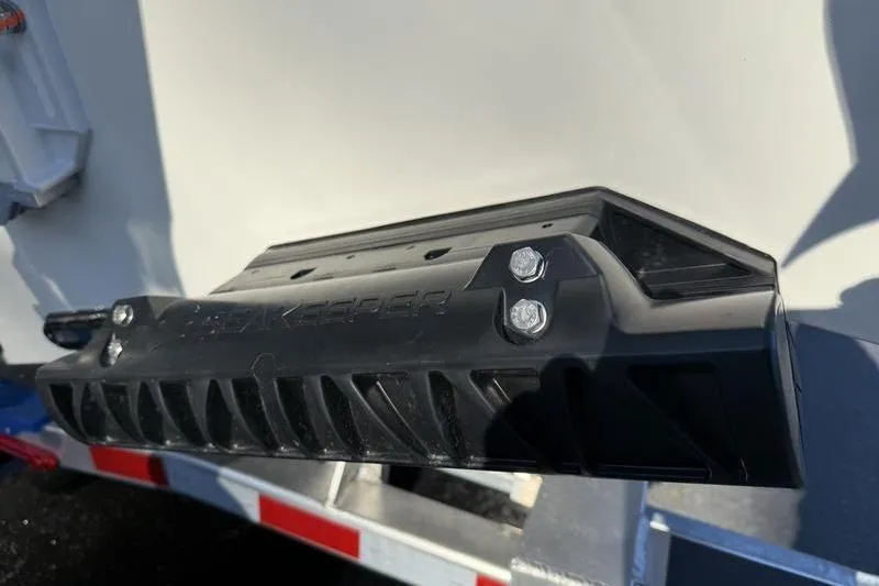 Slide: The Image of 2026 Cobia 265 Open Center Console boat detail with black component on trailer. - 31