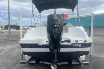 The Image of 2022 Hurricane SunDeck Sport 192 RL OB boat with outboard motor, parked outdoors. - 1