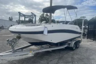Slide: The Image of 2022 Hurricane SunDeck Sport 192 RL OB boat on trailer, parked outdoors. - 5