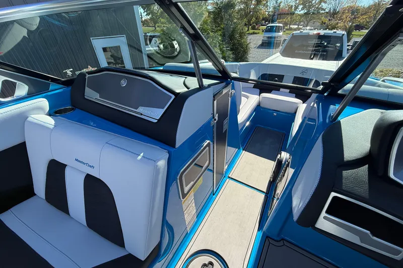 Slide: The Image of 2019 MasterCraft X24 boat interior with blue and white seating, sleek design, and modern features. - 12