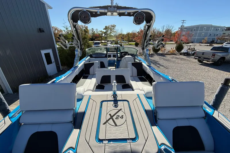 Slide: The Image of 2019 MasterCraft X24 boat interior with seating and wakeboard tower in a sunny outdoor setting. - 13