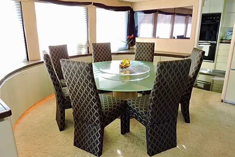 Slide: The Image of Luxurious dining area on 1992 Christensen motor yacht with elegant chairs and glass table. - 11
