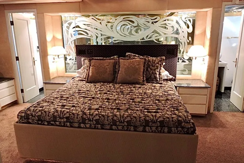 Slide: The Image of Luxurious bedroom interior on a 1992 Christensen motor yacht, featuring elegant bedding and ambient lighting. - 18