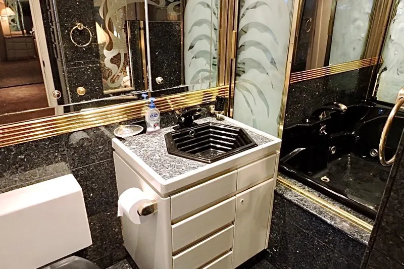 Slide: The Image of Luxurious bathroom on a 1992 Christensen motor yacht with black sink and gold accents. - 20