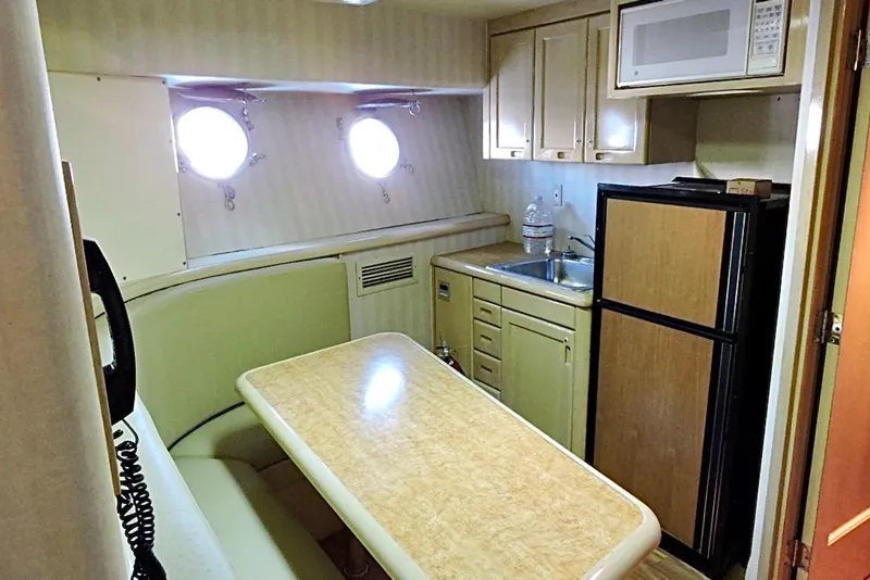 Slide: The Image of Cozy 1992 Christensen motor yacht kitchen with table, sink, fridge, and microwave. - 26