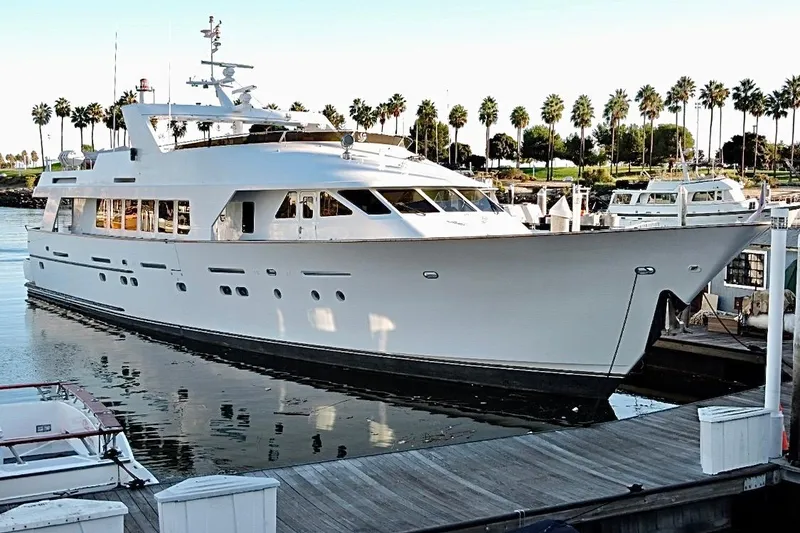 Slide: The Image of Luxurious 1992 Christensen motor yacht docked, surrounded by palm trees and calm waters. - 3