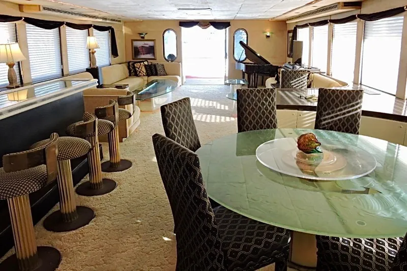 Slide: The Image of Luxurious 1992 Christensen motor yacht interior with elegant seating, bar stools, and a grand piano. - 9