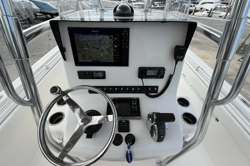 Slide: The Image of 2016 Contender 24 Sport boat console with steering wheel, navigation system, and controls. - 14