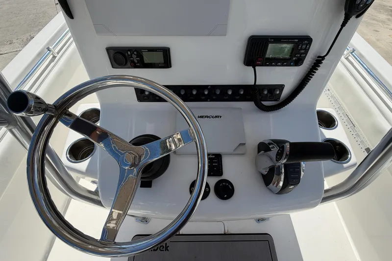 Slide: The Image of 2016 Contender 24 Sport boat dashboard with steering wheel and control panel. - 17