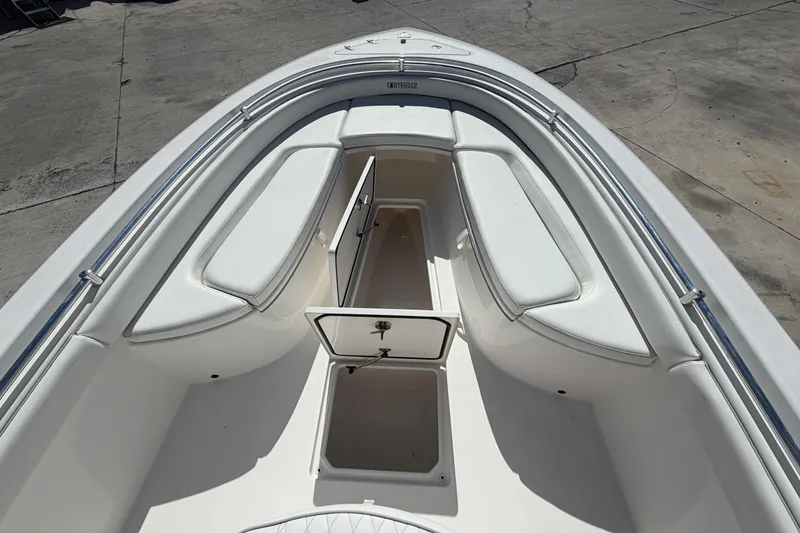Slide: The Image of 2016 Contender 24 Sport boat interior with open storage compartments and cushioned seating. - 19