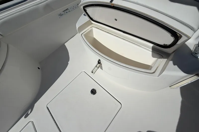 Slide: The Image of 2016 Contender 24 Sport boat interior storage compartment, open lid, white finish. - 23