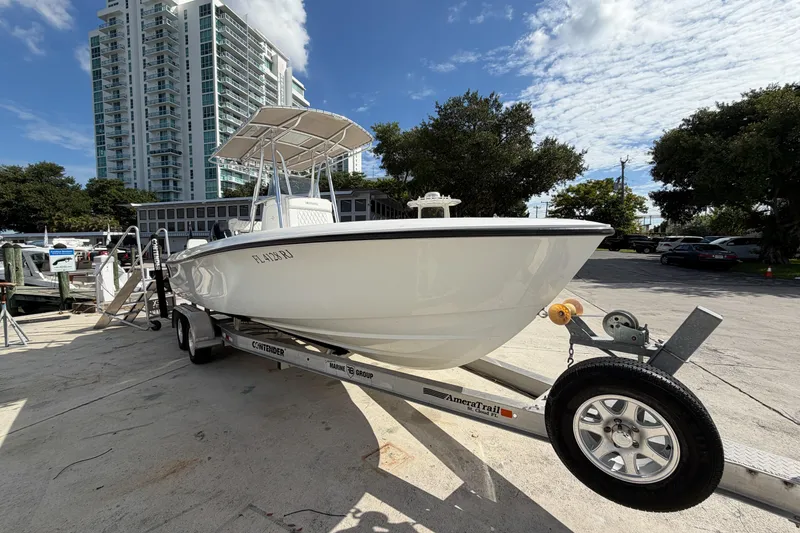 Slide: The Image of 2016 Contender 24 Sport boat on trailer, urban backdrop, clear sky. - 3