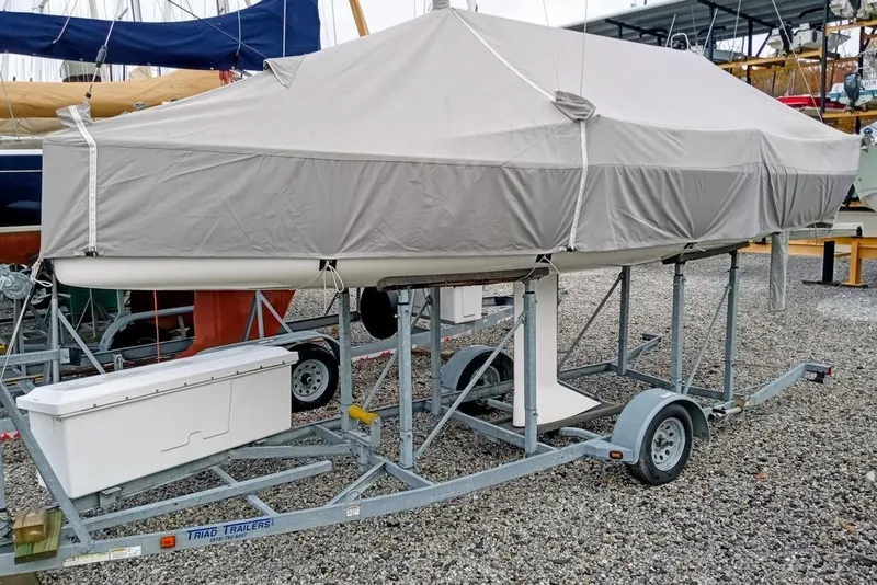 Slide: The Image of Covered 2016 J Boats J/70 sailboat on trailer in a gravel lot. - 16