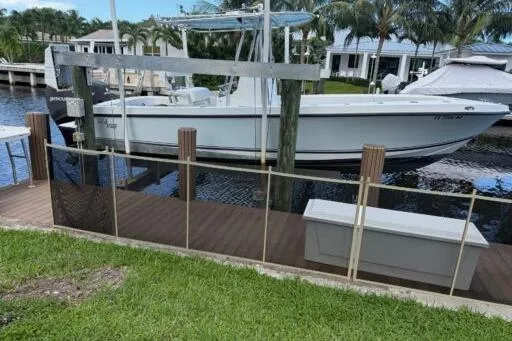 The Image of 2006 SeaVee 260 boat docked by waterfront homes with lush greenery. - 1