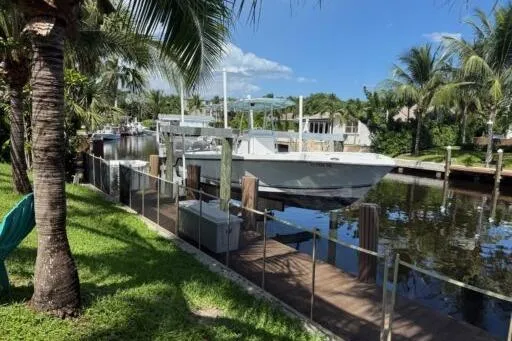 Slide: The Image of 2006 SeaVee 260 boat docked in a tropical canal setting with palm trees. - 3