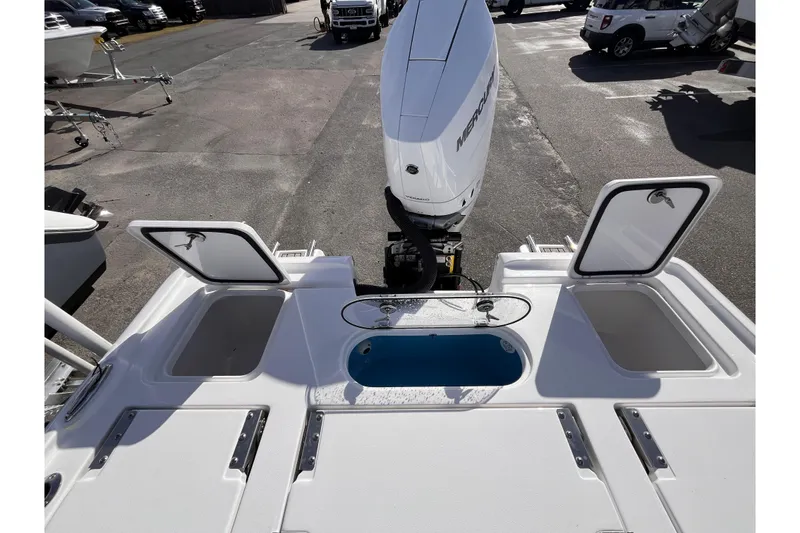 Slide: The Image of 2026 Tidewater 2500 Carolina Bay boat with open storage compartments and Mercury engine. - 16