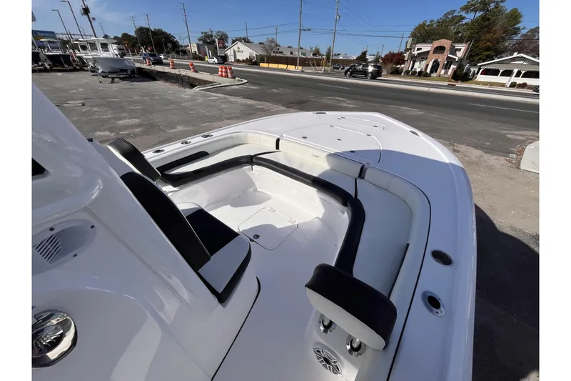 Slide: The Image of 2026 Tidewater 2500 Carolina Bay boat with spacious seating, parked near a road. - 9