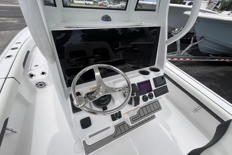 Slide: The Image of 2026 Tidewater 2500 Carolina Bay boat console with steering wheel and controls. - 9