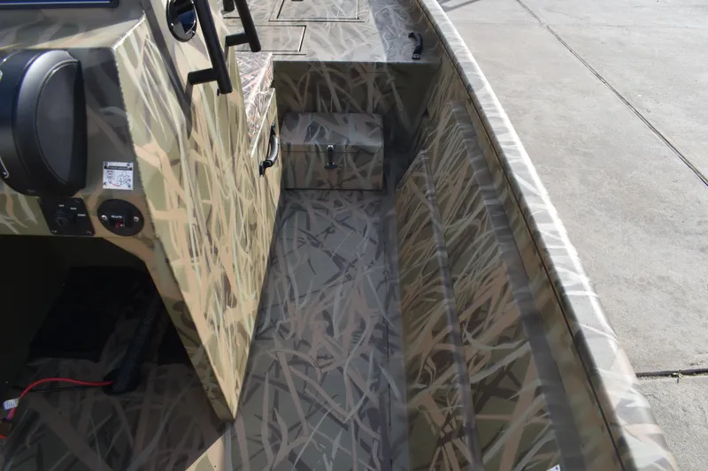 Slide: The Image of 2026 Lowe Roughneck RX1860 Tunnel Jet boat with open storage compartment, camo design. - 19