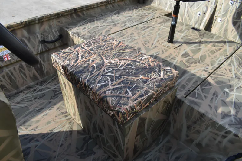 Slide: The Image of 2026 Lowe Roughneck RX1860 Tunnel Jet boat storage compartment with camouflage design. - 25