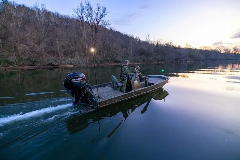 Slide: The Image of 2026 Lowe Roughneck RX1860 Tunnel Jet boat on trailer, camo design, outdoor setting. - 9