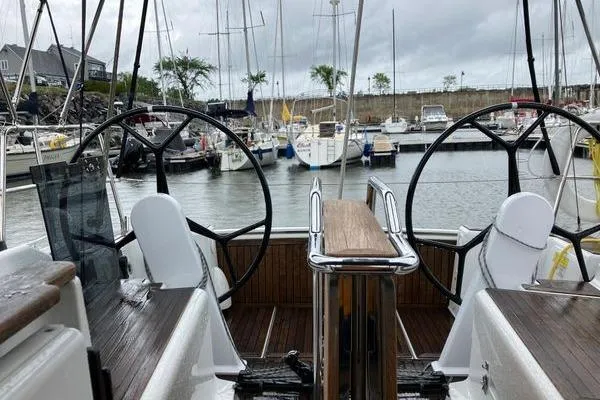Slide: The Image of 2017 Hanse 315 sailboat cockpit with dual steering wheels in a marina setting. - 16