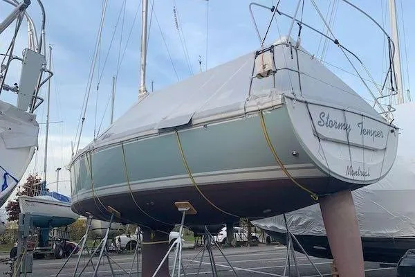 Slide: The Image of 2017 Hanse 315 sailboat on stands, covered and stored outdoors. - 2