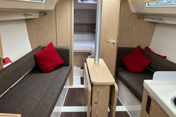 Slide: The Image of Interior of 2017 Hanse 315 sailboat with cozy seating and red cushions. - 24