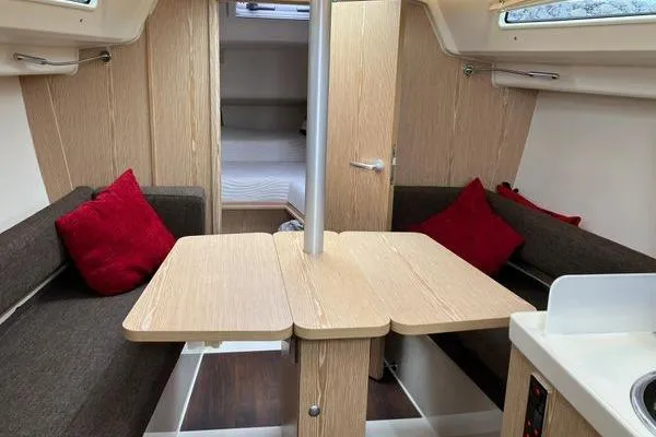 Slide: The Image of Interior of 2017 Hanse 315 sailboat with cozy seating and red cushions. - 25