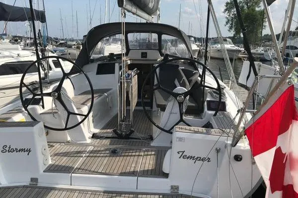 Slide: The Image of 2017 Hanse 315 sailboat with dual steering wheels, docked in a marina. - 3