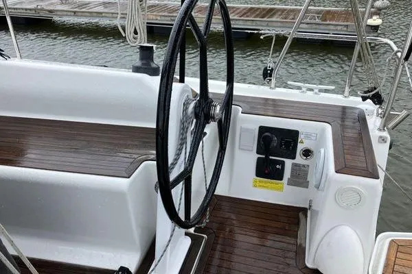 Slide: The Image of Steering wheel and controls of a 2017 Hanse 315 sailboat, docked by the water. - 7
