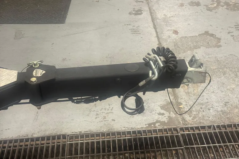 Slide: The Image of Trailer hitch of a 2019 Triton 18 TrX boat on concrete surface. - 13