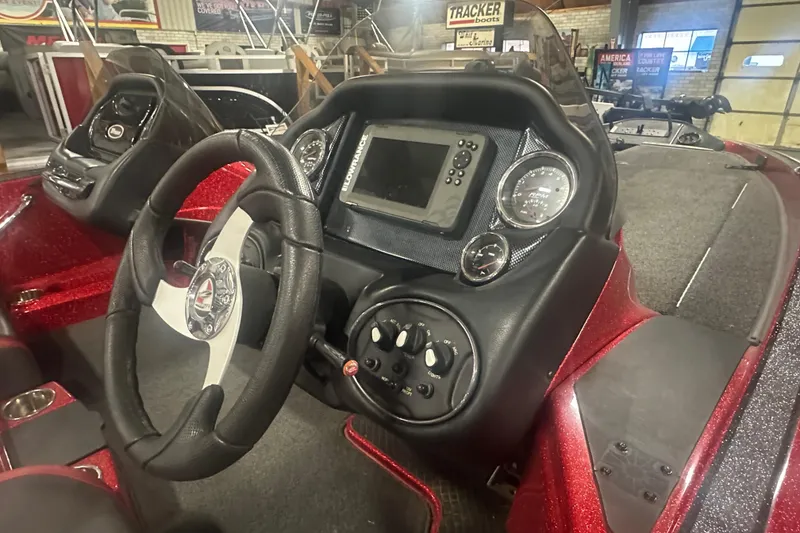 Slide: The Image of 2019 Triton 18 TrX boat dashboard with steering wheel and electronic display. - 14