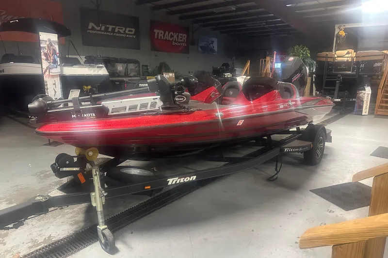 Slide: The Image of 2019 Triton 18 TrX bass boat in showroom, red color, on trailer. - 3