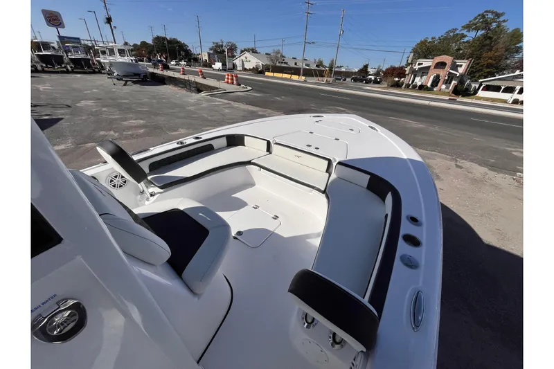 Slide: The Image of 2026 Tidewater 2300 Carolina Bay boat interior with seating, parked near a road. - 10