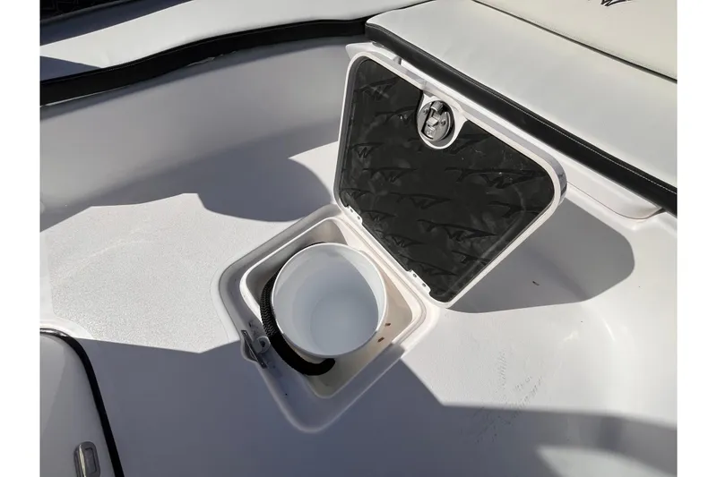 Slide: The Image of 2026 Tidewater 2300 Carolina Bay boat storage compartment with open lid and bucket. - 12