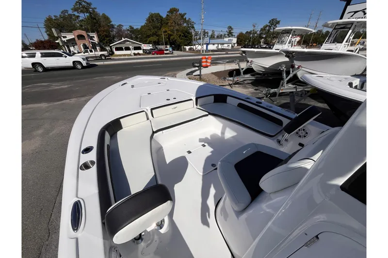 Slide: The Image of 2026 Tidewater 2300 Carolina Bay boat interior with seating and console, parked outdoors. - 13