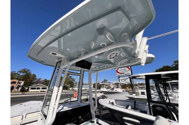 Slide: The Image of 2026 Tidewater 2300 Carolina Bay boat with T-top and speakers, displayed at a marina. - 17